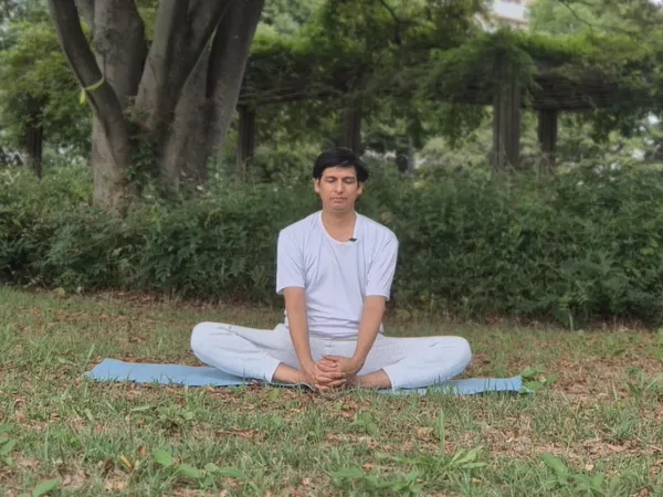 A person sitting in Bound Angle Pose with blankets under their knees for support.