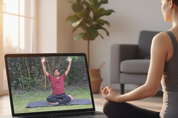 A person practicing yoga at home with a laptop.